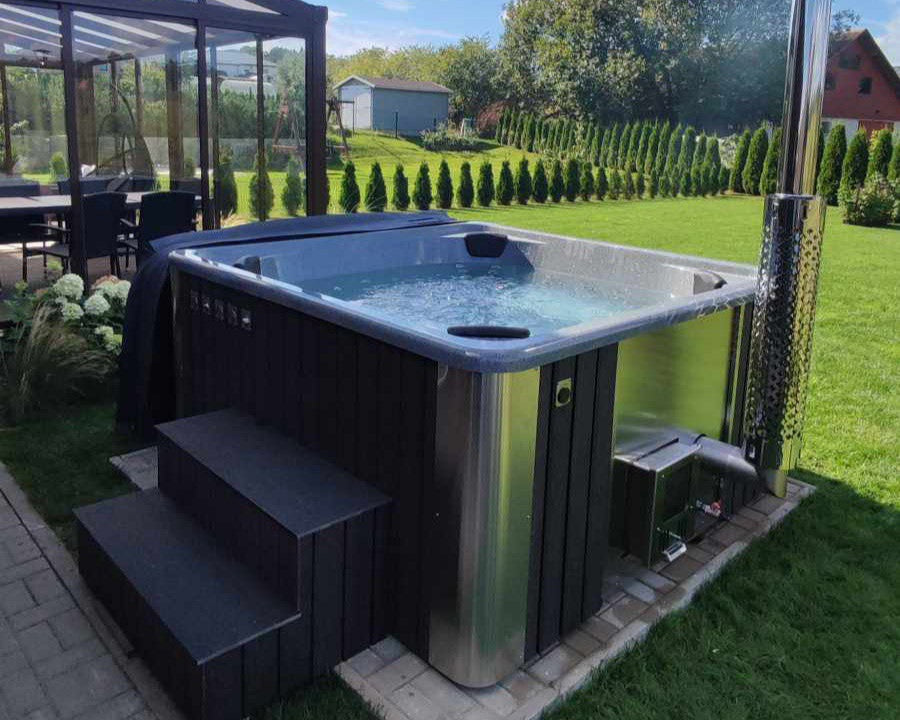Hot tub in a garden setting with a clear sky